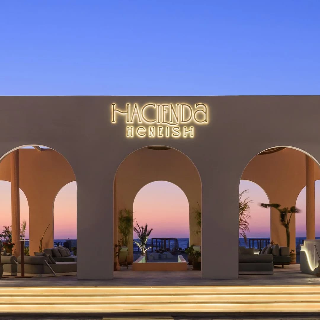 Illuminated Hacienda Heneish entrance and arched sea view at sunset